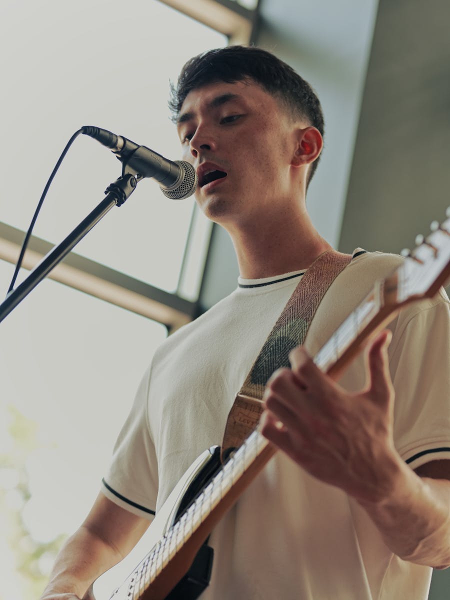 Musician performing with an electric guitar under moody indoor lighting