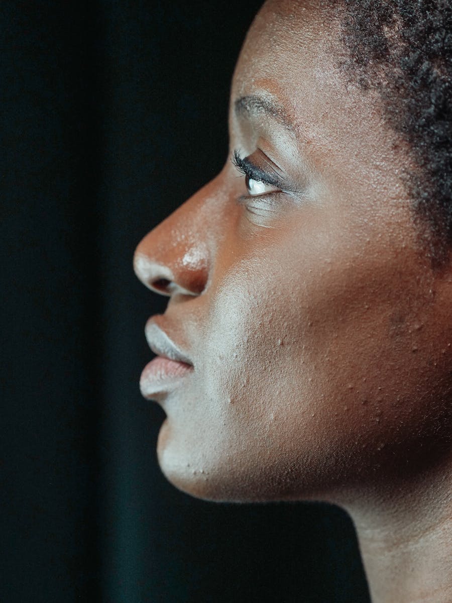 Close side-profile portrait against a dark studio background