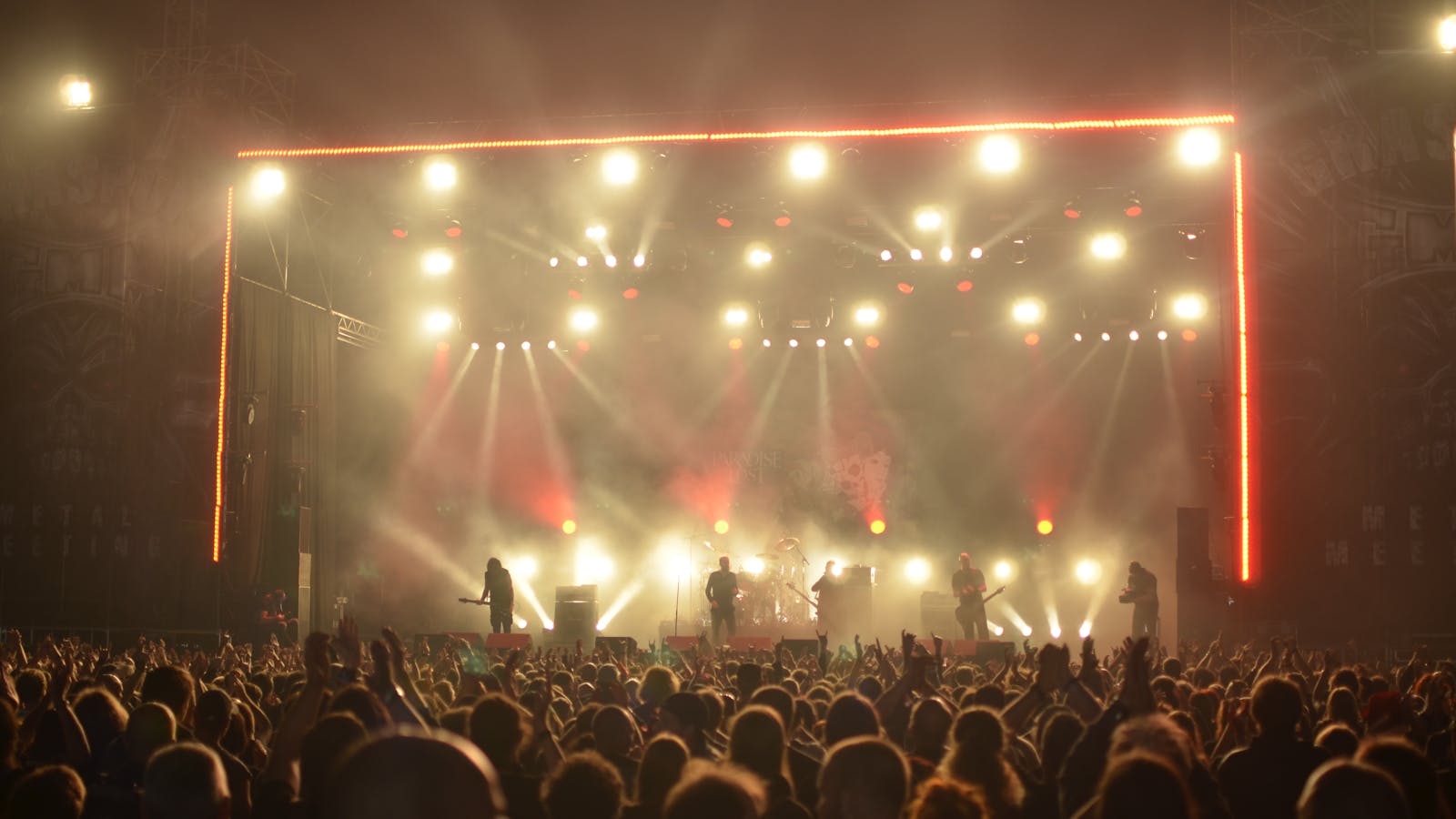 Live band on stage in front of a packed nighttime crowd