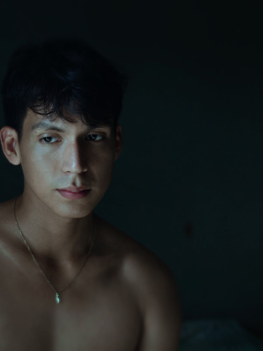 Moody studio portrait of a young man in low light